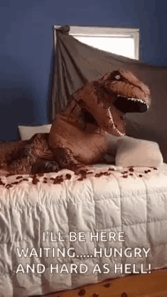 a t-rex costume is laying on a bed with roses on it