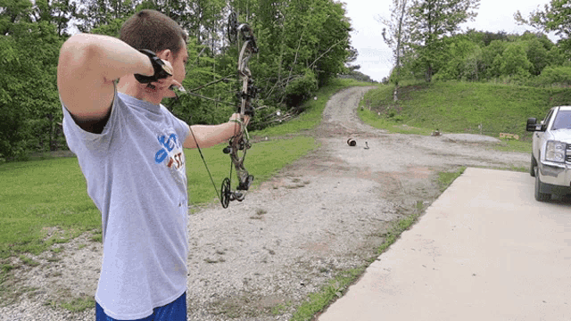 a man holding a bow and arrow while wearing a shirt that says ' texas ' on the front