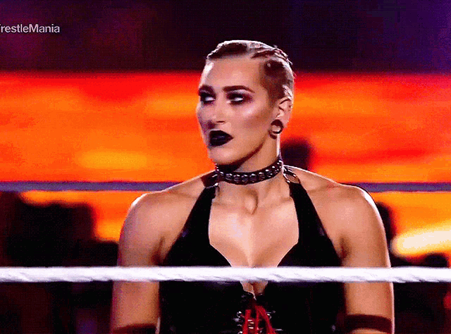 a woman is in a wrestling ring with the words restlemania on the bottom right