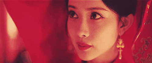 a close up of a woman 's face with a red background .