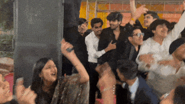 a crowd of people are dancing in a room with a speaker in the background