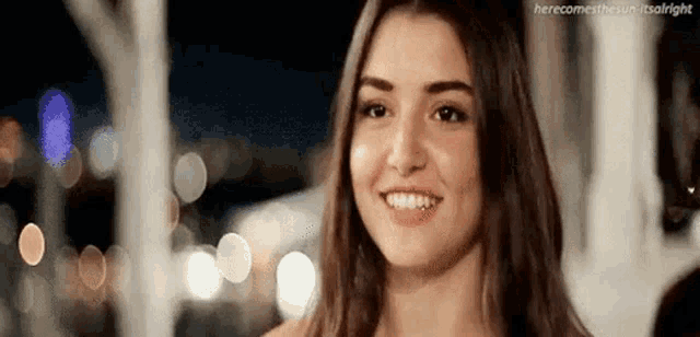 a young woman is smiling and looking at the camera .
