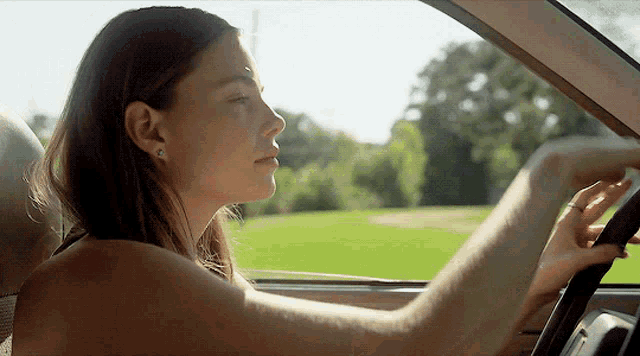 a woman in a car with her eyes closed