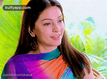 a close up of a woman wearing a saree and smiling .