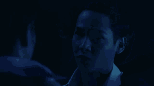 a person 's face is obscured by a blue background