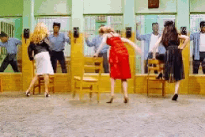 a group of people are dancing in a room with chairs and mirrors