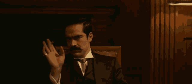 a man with a mustache and a ring on his finger