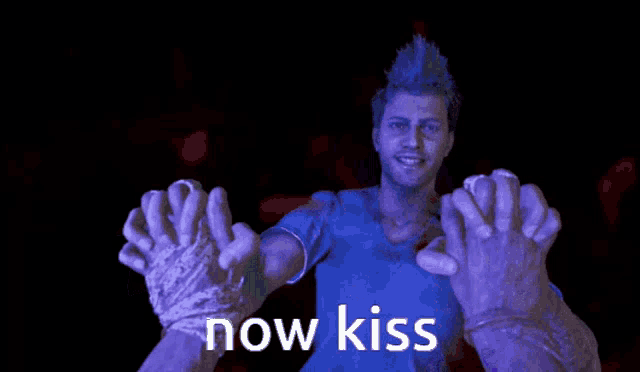 a man in a blue shirt is surrounded by purple hands that say " now kiss "