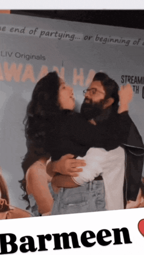 a man is holding a woman in his arms in front of a sign that says the end of partying