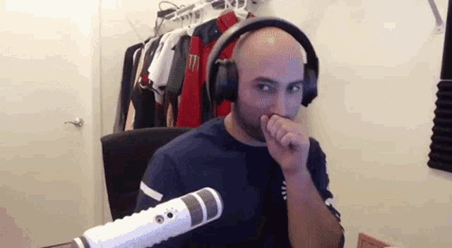 a man wearing headphones is sitting in front of a microphone .