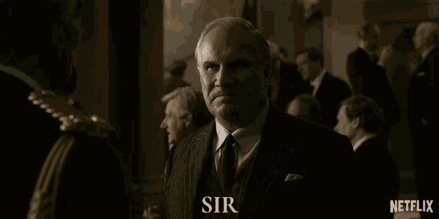 a group of men are standing in a room and the word sir is on the bottom left