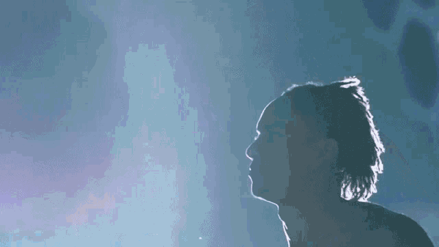 a man is standing in front of a purple light