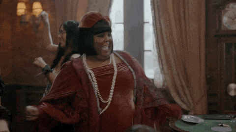 a woman in a red dress and hat is dancing