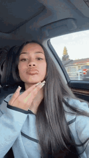 a woman with long hair is sitting in the back seat of a car