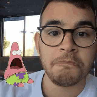 a man wearing glasses and a patrick star sticker