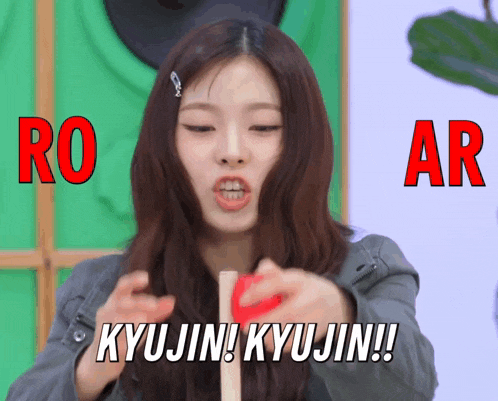 a woman is holding a red object and says kyujin kyujin !!
