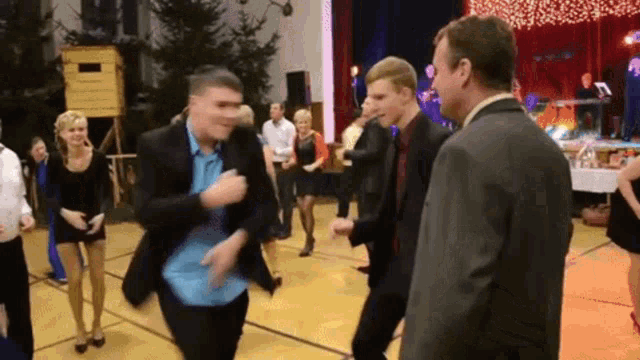 a group of people are dancing on a dance floor in front of a stage