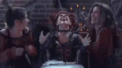 a woman in a witch costume says " cackles in bruja spanish " while two other women look on