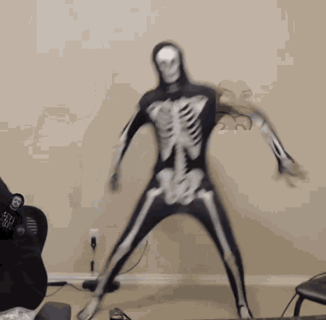 a man in a skeleton costume is standing in front of a chair