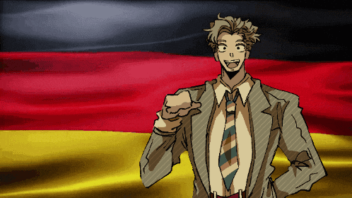 a man in a suit and tie pointing at the camera in front of a german flag