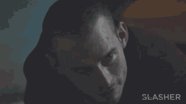 a close up of a man 's face with the word slasher on the bottom right