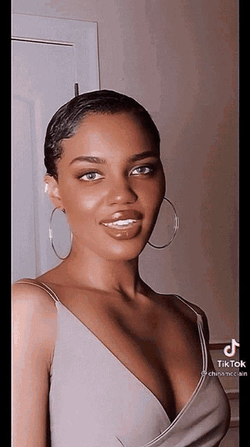 a woman wearing hoop earrings and a plunging neckline is a tiktok star