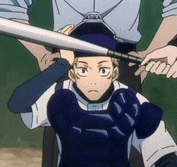 a baseball player is holding a bat over his head while a referee watches .