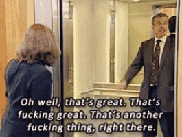 a man in a suit and tie is standing next to a woman in an elevator and talking to her .