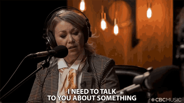 a woman wearing headphones says " i need to talk to you about something " in front of a microphone