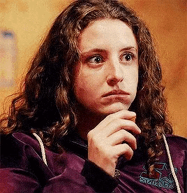 a girl with curly hair wearing a purple jacket that says squirrel on it