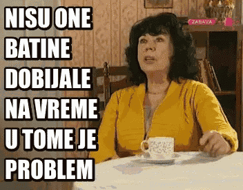 a woman in a yellow shirt is sitting at a table with a cup of coffee and a sign that says zabava