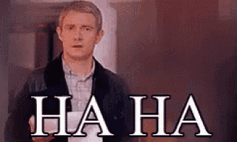 a man is standing in a hallway with the words `` ha ha '' written on the wall behind him .