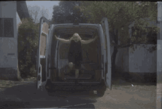 a man jumps out of the back of a van