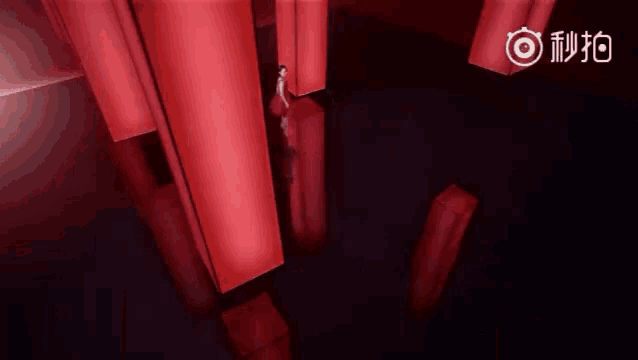 a woman in a red dress is standing in front of red cubes