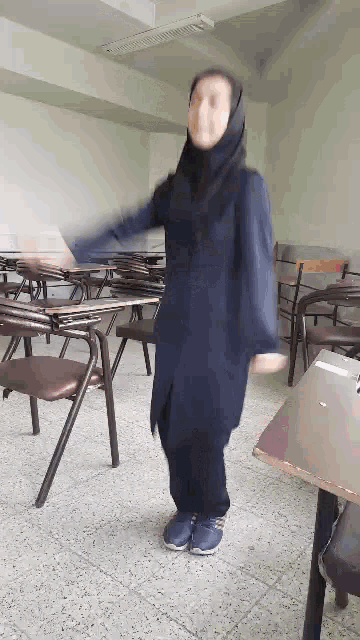 a woman is dancing in a classroom with chairs .