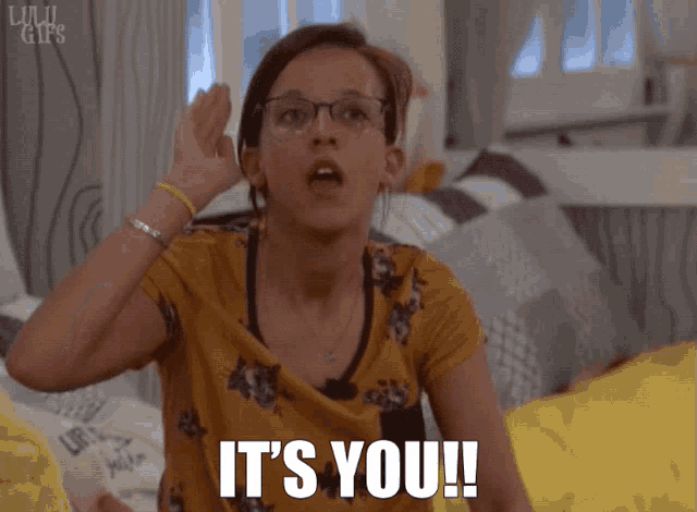 a girl with glasses and a yellow shirt says it 's you '