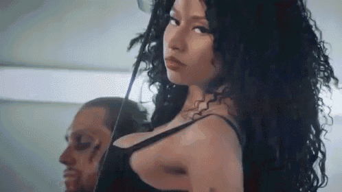 a woman in a black bra is standing in front of a man .