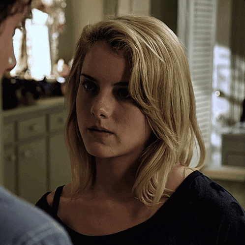 a close up of a woman 's face with a man in the background