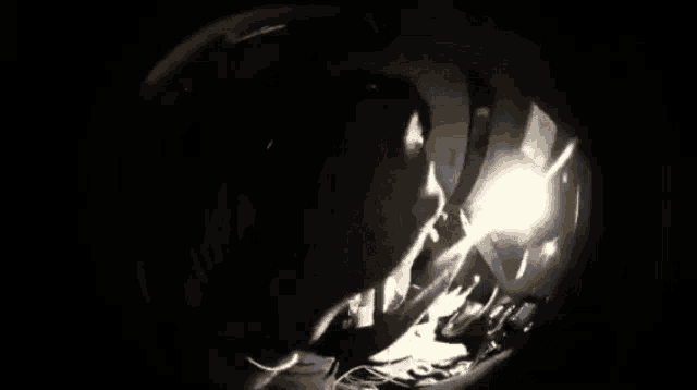 a person sitting in a dark room with a reflection of a person in a mirror