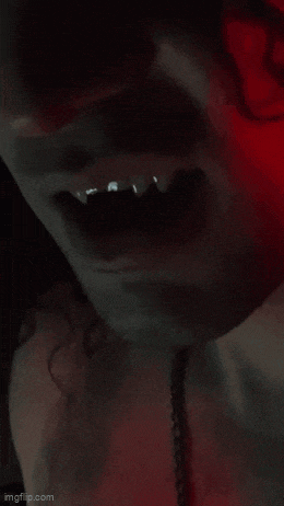 a close up of a vampire 's mouth with teeth visible