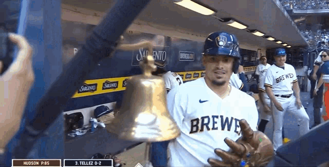 a man in a brewer jersey holds a bell