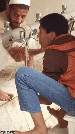 a man is washing a child 's feet in a bathroom .