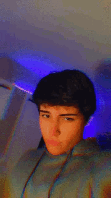 a blurry picture of a young man 's face with a blue background