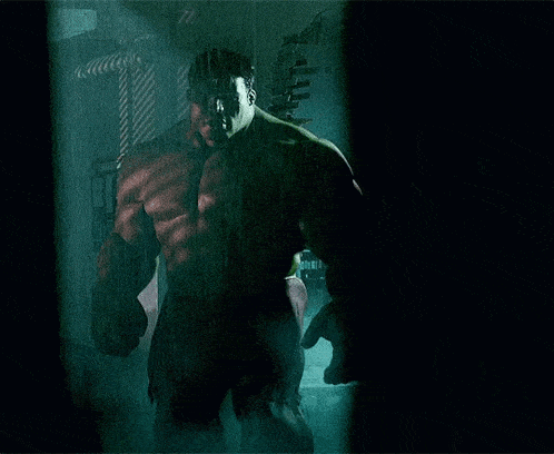 the hulk is standing in a dark room with a reflection of himself in the window