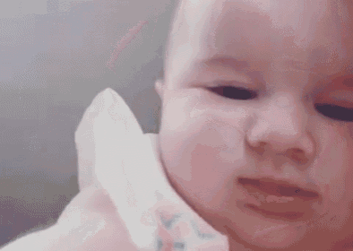 a close up of a baby 's face with a tissue on it .