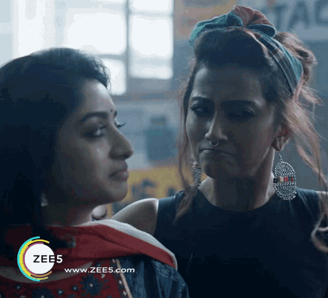 two women are standing next to each other with the words zee5 www.zees.com on the bottom right
