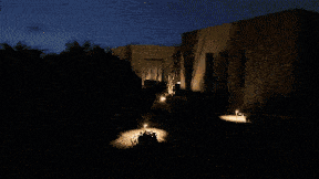 a house that is lit up at night with a car parked in front of it