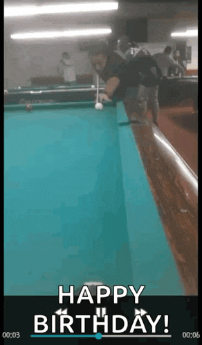 a man is playing pool on a pool table with the words happy birthday written on the screen .