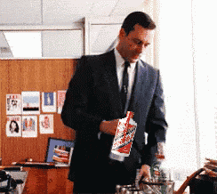 a man in a suit and tie is holding a bottle of soda