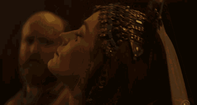 a woman with a veil and a crown on her head looks at a man